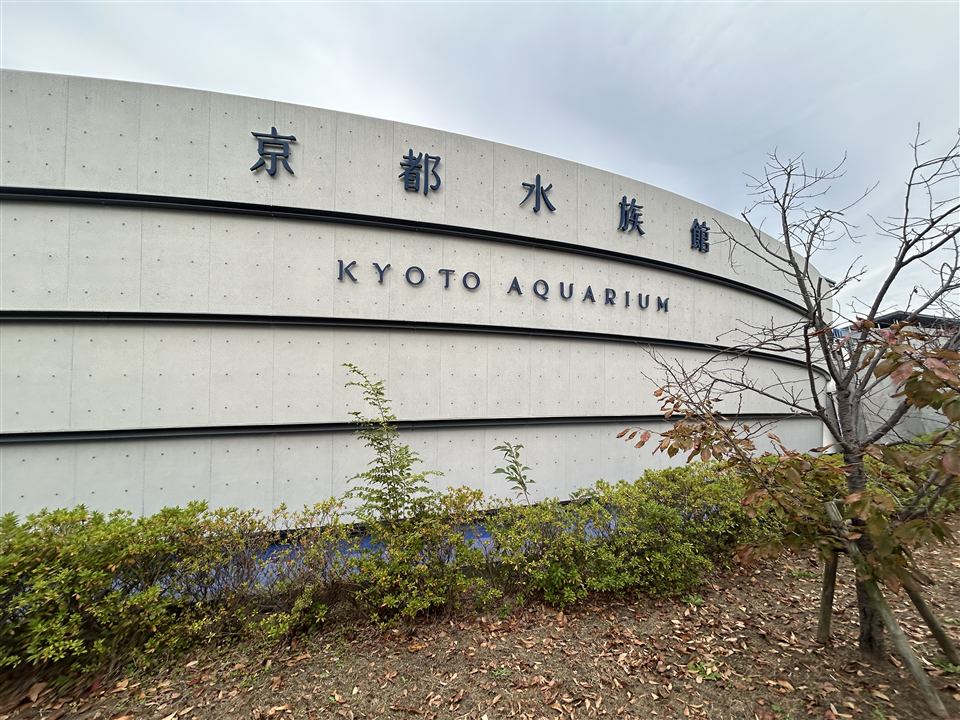 The curved exterior wall of the Kyoto Aquarium with its name in Japanese and English