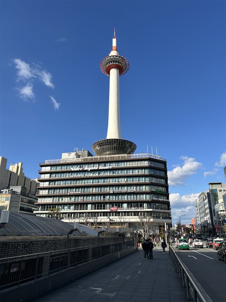 Kyoto Tower above the Kyoto Station area under a blue sky