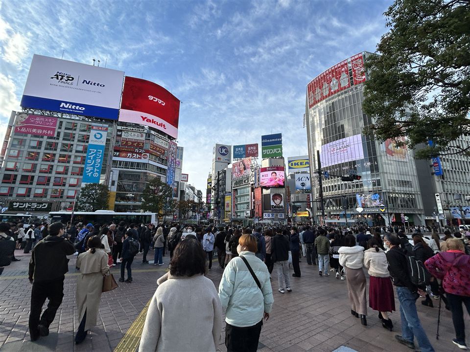 Crowds at Shibuya Scramble Crossing in Tokyo, with the Tsutaya building Starbucks on the right